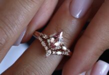 Rose gold ring set with a kite-shaped pink gemstone and small diamonds, worn on a finger