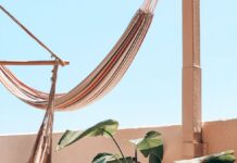 Relaxing terrace with a hammock, wooden furniture and a potted plant